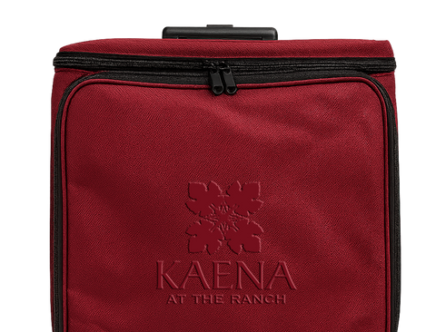 Red suitcase with 'Kaena at the Ranch' logo on a white background
